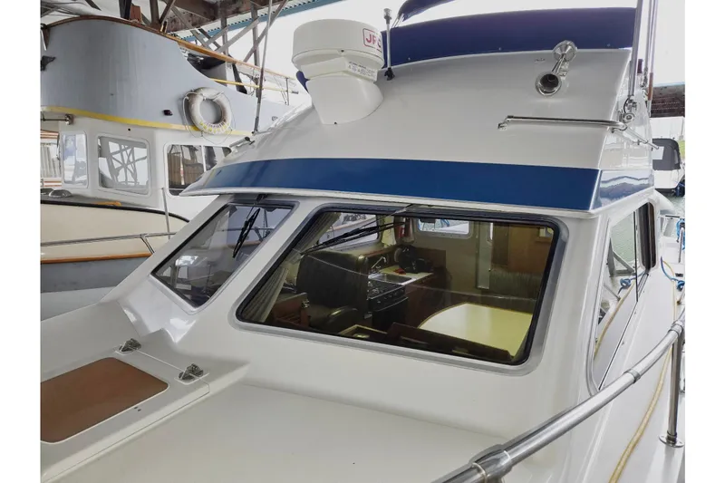 Slide: The Image of 2001 Commander Flybridge Sedan boat docked in a marina, showcasing its cabin and exterior design. - 3