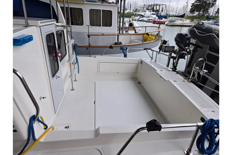 Slide: The Image of 2001 Commander Flybridge Sedan boat deck with marina view, featuring clean white surfaces. - 30