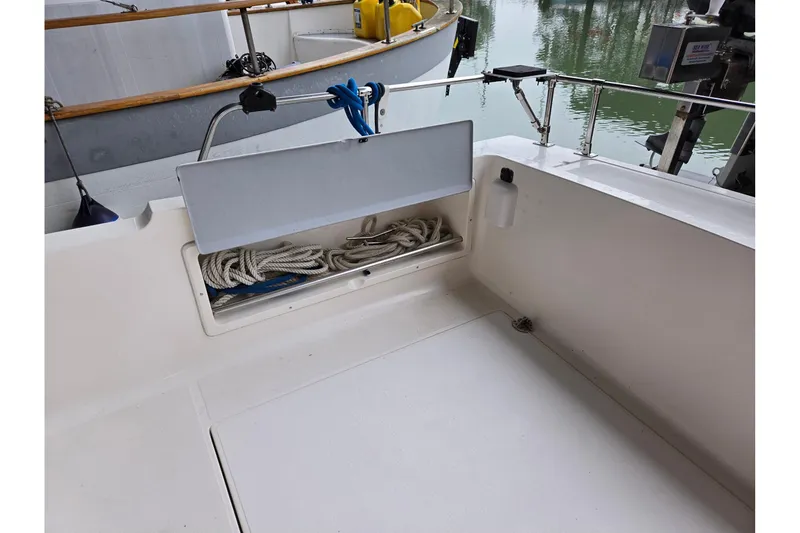 Slide: The Image of 2001 Commander Flybridge Sedan boat deck with storage compartment and coiled rope. - 31