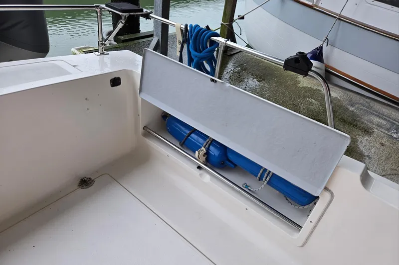 Slide: The Image of 2001 Commander Flybridge Sedan boat deck with storage compartment and blue fender. - 32