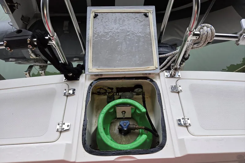 Slide: The Image of 2001 Commander Flybridge Sedan boat compartment with green hose and equipment. - 34
