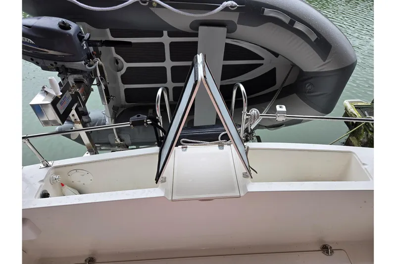 Slide: The Image of 2001 Commander Flybridge Sedan boat with outboard motor and inflatable dinghy on water. - 35