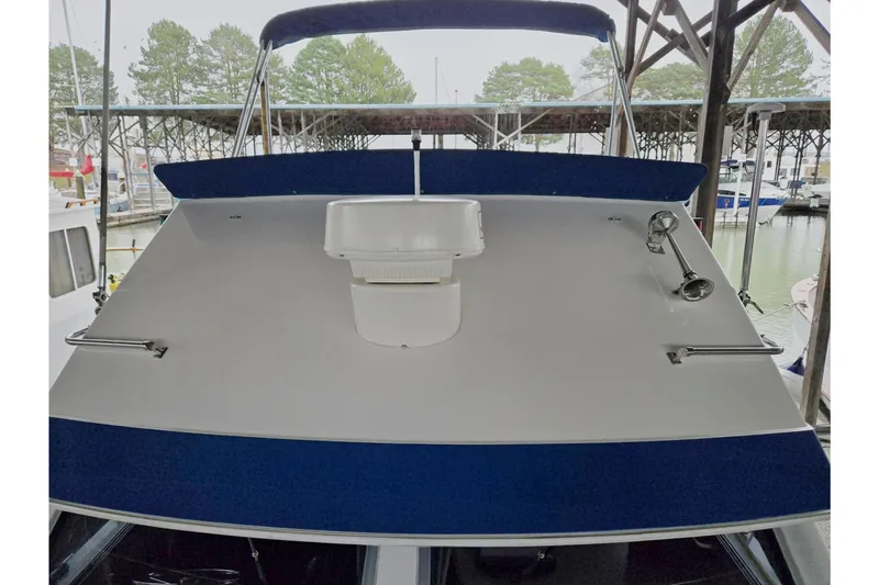 Slide: The Image of 2001 Commander Flybridge Sedan boat docked in marina, front view. - 4