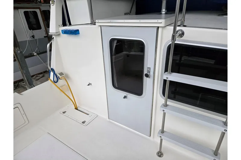 Slide: The Image of 2001 Commander Flybridge Sedan boat with ladder and door, featuring utility connections. - 48
