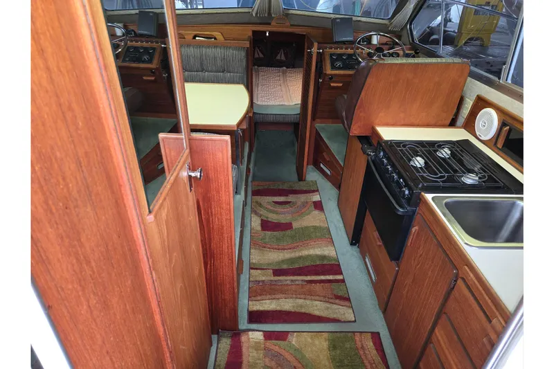 Slide: The Image of Interior of 2001 Commander Flybridge Sedan with wood finish, kitchen, and steering area. - 51