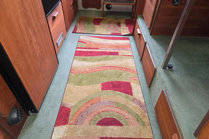 Slide: The Image of Interior of 2001 Commander Flybridge Sedan with colorful patterned rugs and wooden cabinetry. - 52