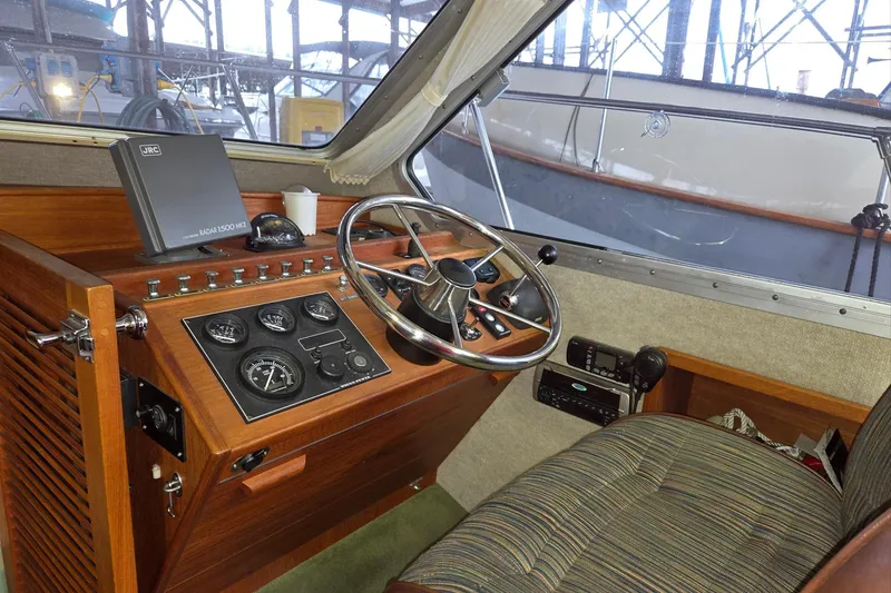 Slide: The Image of 2001 Commander Flybridge Sedan helm with wooden dashboard and steering wheel. - 55