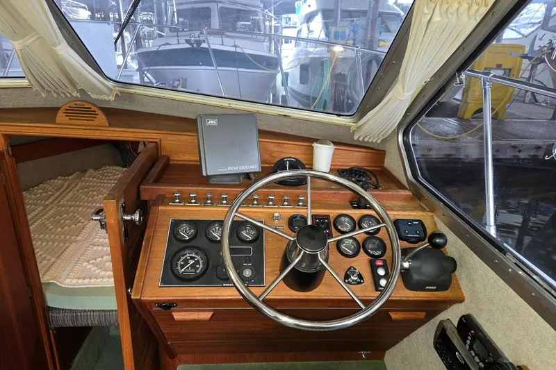 Slide: The Image of 2001 Commander Flybridge Sedan helm with steering wheel, gauges, and radar system. - 56