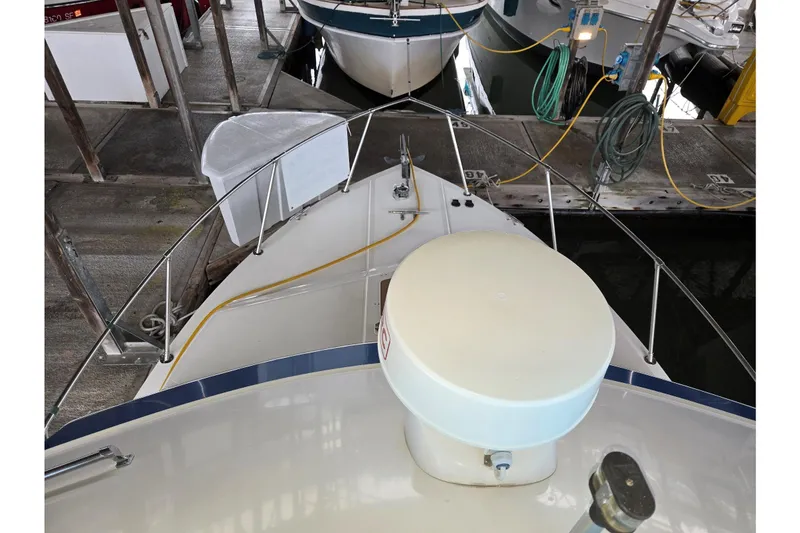 Slide: The Image of 2001 Commander Flybridge Sedan docked, showing bow and marina setup. - 6