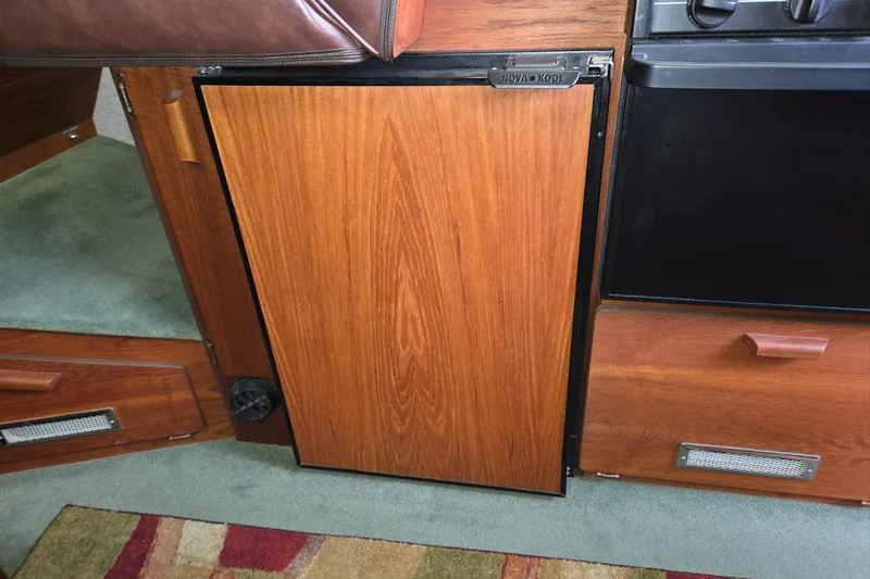 Slide: The Image of Wood-paneled interior of 2001 Commander Flybridge Sedan with Nova Kool fridge. - 75