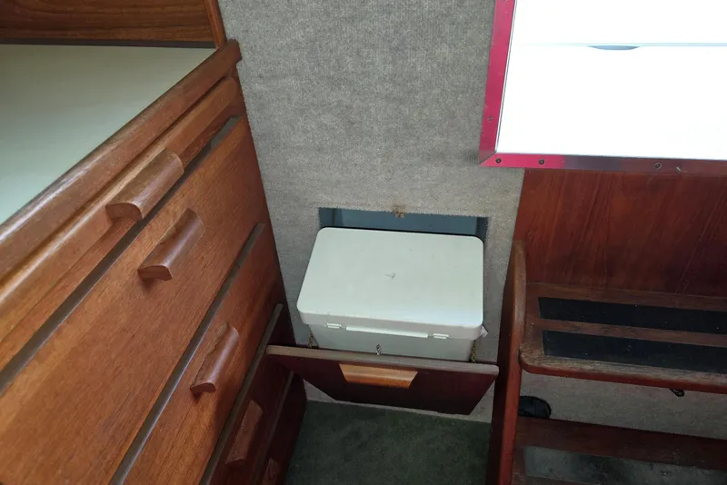 Slide: The Image of Interior of 2001 Commander Flybridge Sedan with wooden cabinetry and storage compartment. - 77