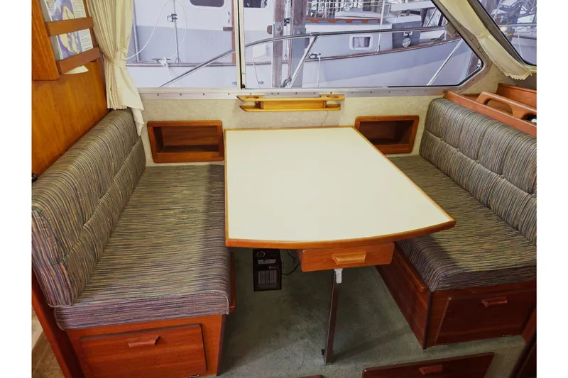 Slide: The Image of 2001 Commander Flybridge Sedan interior with dining area and striped seating. - 80