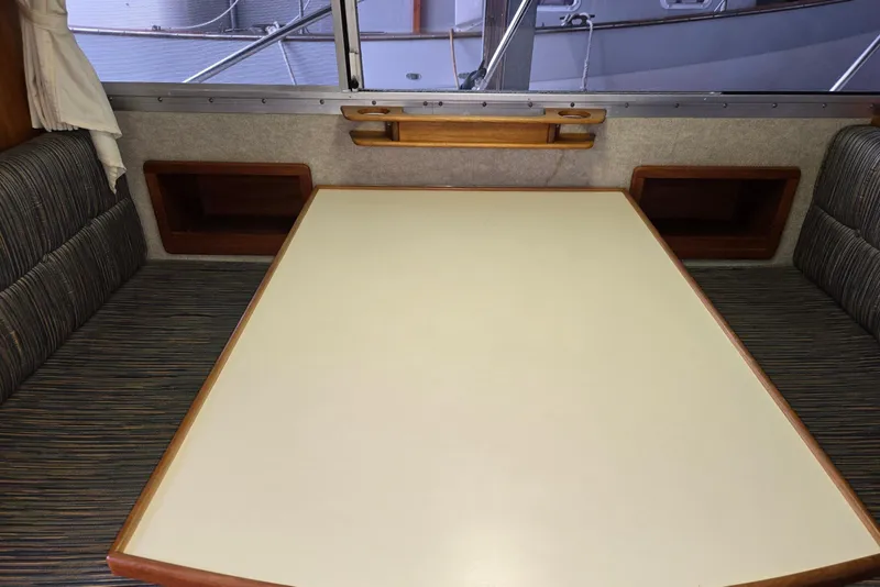 Slide: The Image of 2001 Commander Flybridge Sedan interior with dining table and cushioned seating. - 83