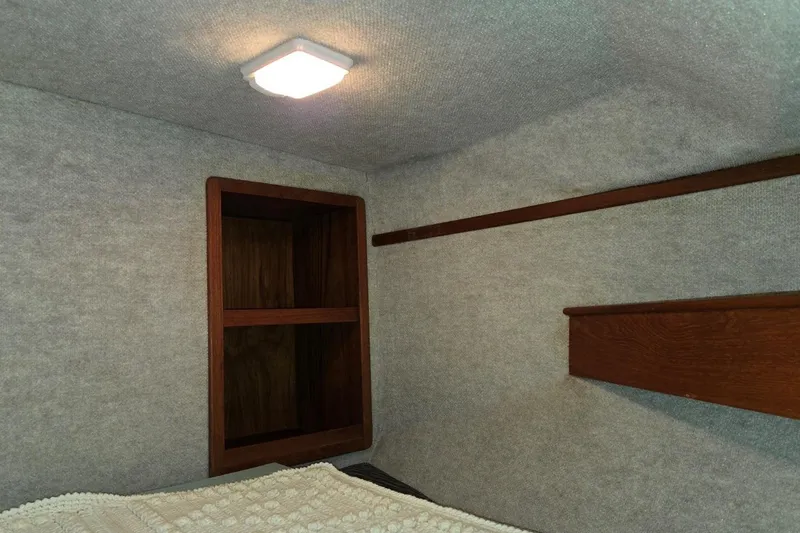 Slide: The Image of Interior cabin of 2001 Commander Flybridge Sedan with wooden shelves and cozy lighting. - 90