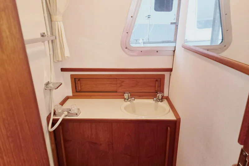 Slide: The Image of 2001 Commander Flybridge Sedan bathroom with wooden cabinetry and a small window. - 93