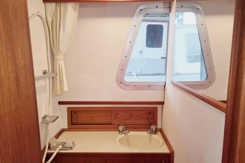 Slide: The Image of 2001 Commander Flybridge Sedan bathroom with sink, window, and shower curtain. - 94