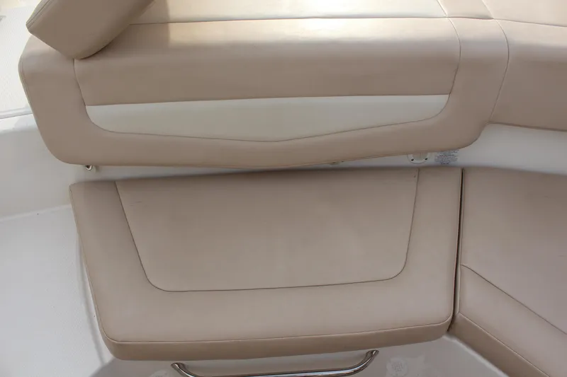 Slide: The Image of 2011 Chaparral 216 SSi boat interior with beige seating and white accents. - 10
