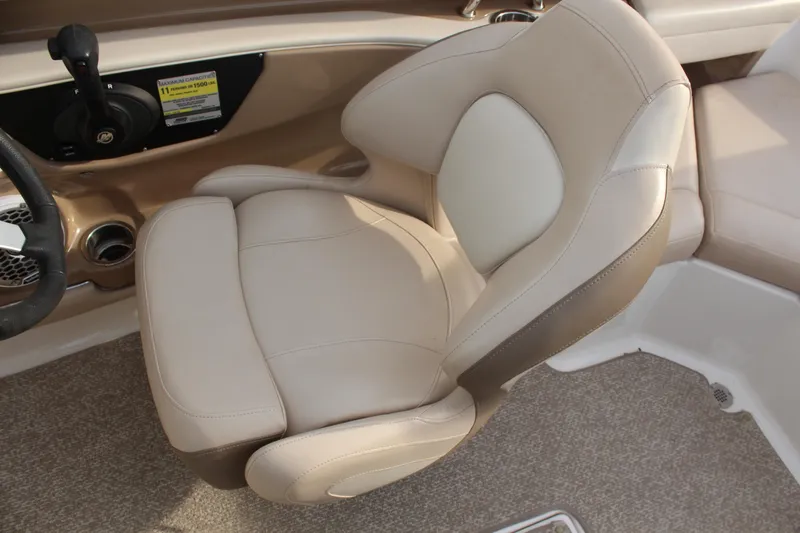 Slide: The Image of 2011 Chaparral 216 SSi boat interior with beige captain's chair and control panel. - 12