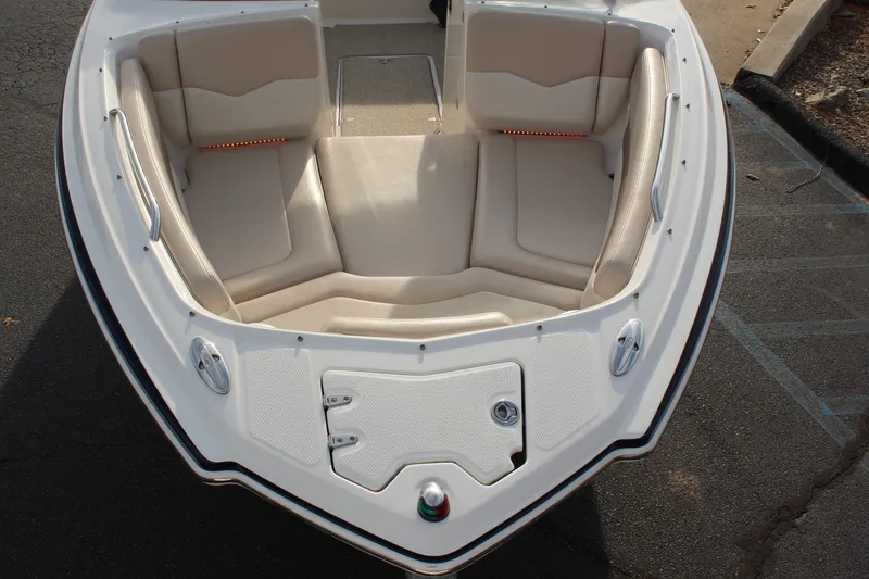 Slide: The Image of 2011 Chaparral 216 SSi boat interior with beige seating and storage compartments. - 17