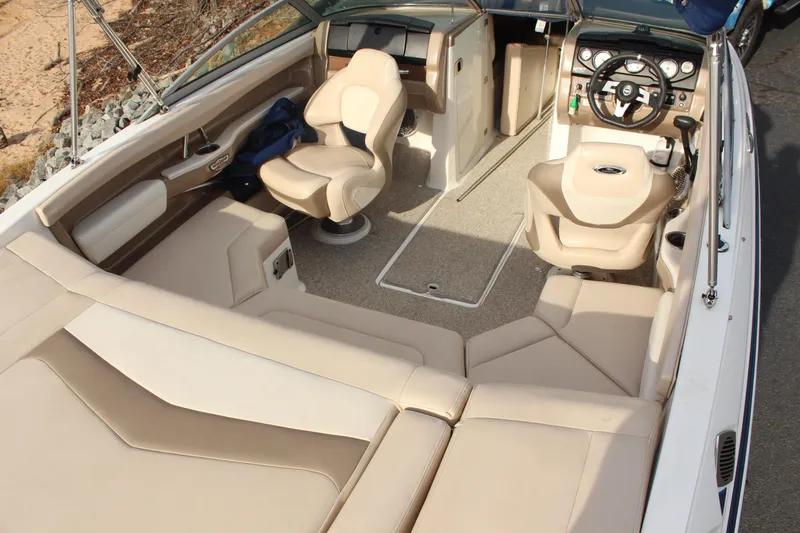 Slide: The Image of 2011 Chaparral 216 SSi boat interior with beige seating and modern dashboard. - 4