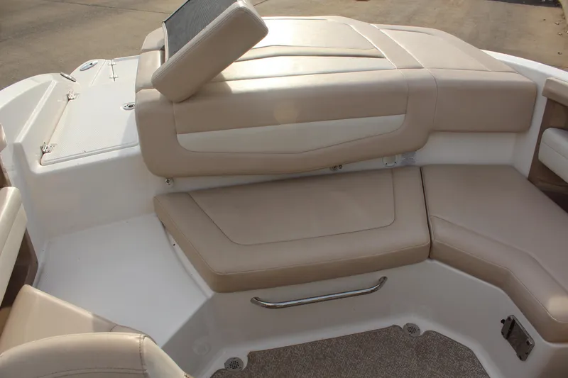 Slide: The Image of 2011 Chaparral 216 SSi boat interior with beige seating and storage area. - 8