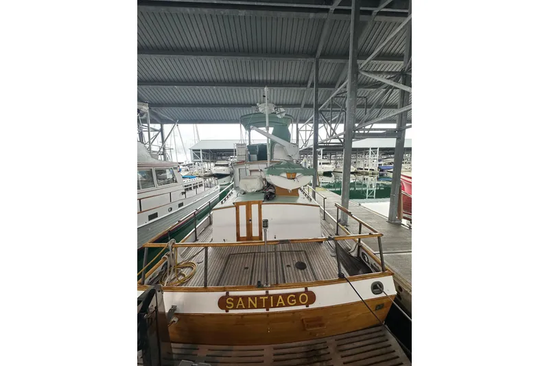 Slide: The Image of 1973 Grand Banks 36 Classic boat docked in a marina under a covered structure. - 11