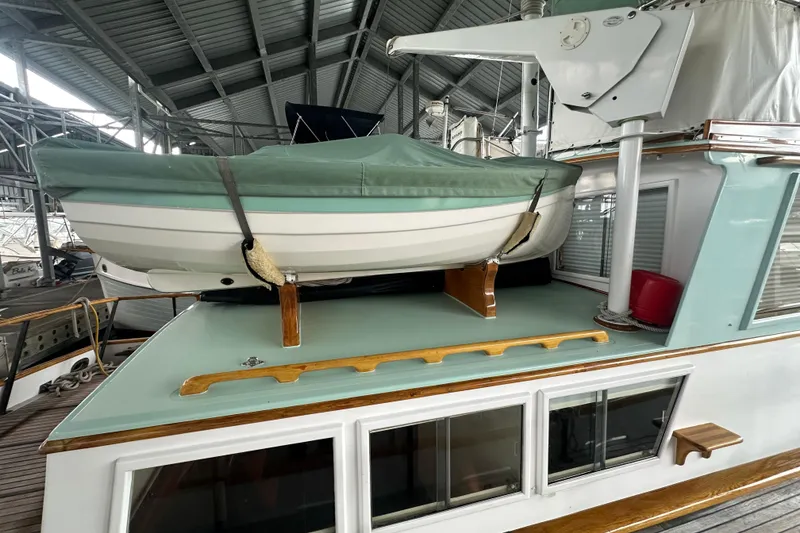 Slide: The Image of 1973 Grand Banks 36 Classic yacht with covered dinghy on deck in marina. - 13