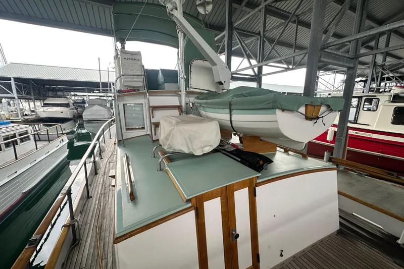 Slide: The Image of 1973 Grand Banks 36 Classic yacht docked with covered dinghy on deck. - 14
