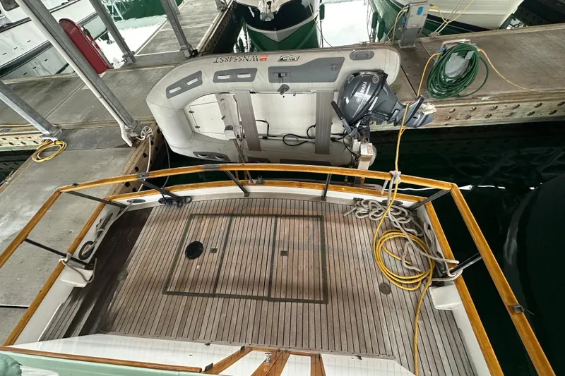 Slide: The Image of 1973 Grand Banks 36 Classic yacht with wooden deck and attached dinghy at marina. - 18