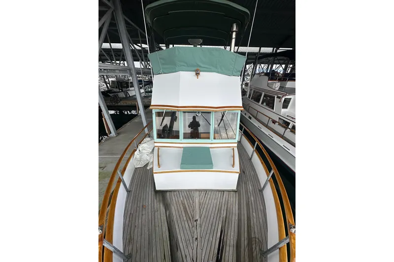 Slide: The Image of 1973 Grand Banks 36 Classic yacht docked, featuring wooden deck and green canopy. - 2