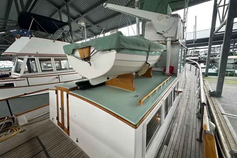 Slide: The Image of 1973 Grand Banks 36 Classic yacht with a covered dinghy on deck, docked in a marina. - 24