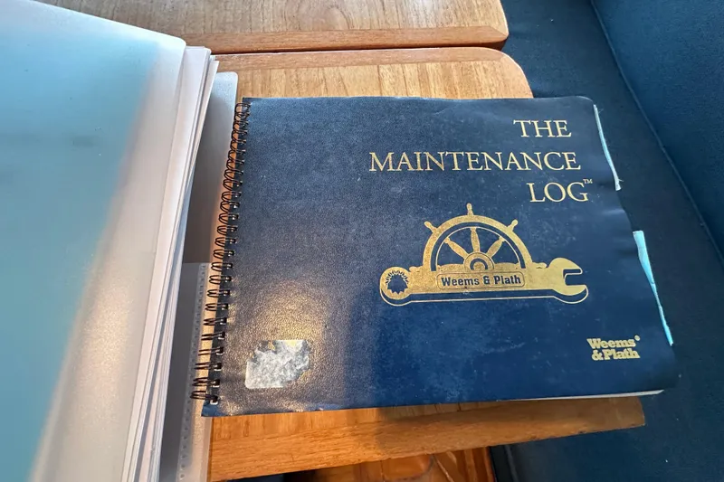 Slide: The Image of 1973 Grand Banks 36 Classic maintenance logbook by Weems & Plath on wooden table. - 28