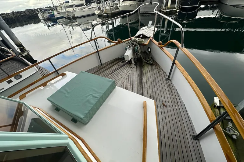 Slide: The Image of 1973 Grand Banks 36 Classic yacht bow with wooden deck and marina view. - 3