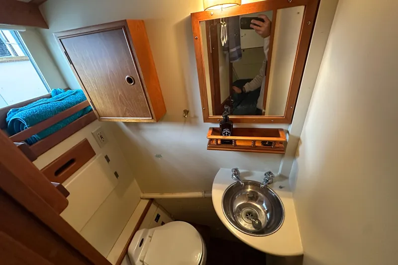 Slide: The Image of 1973 Grand Banks 36 Classic boat bathroom with sink, mirror, and storage cabinet. - 32