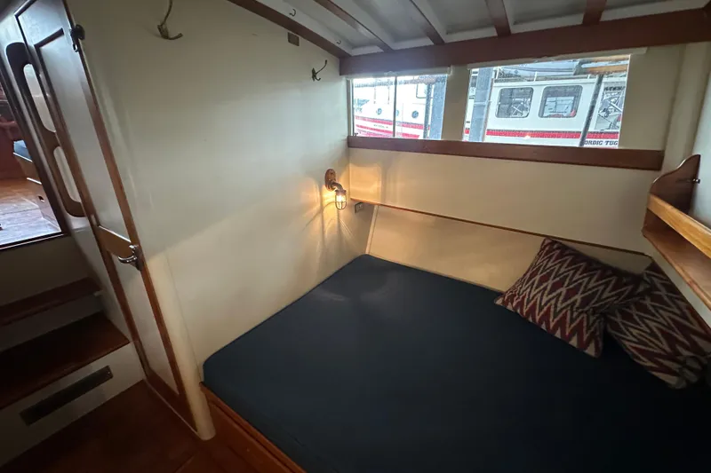 Slide: The Image of 1973 Grand Banks 36 Classic cabin interior with cozy bed and nautical decor. - 37
