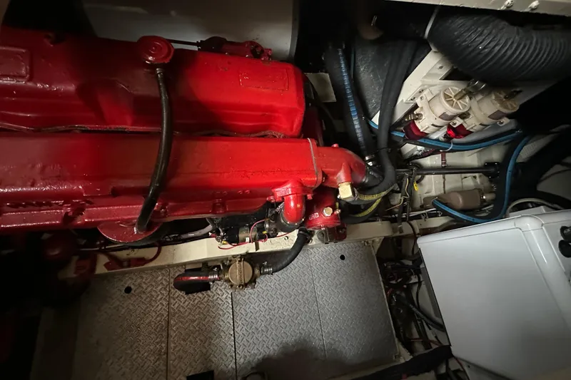 Slide: The Image of Engine room of a 1973 Grand Banks 36 Classic with red engine components and various hoses. - 40