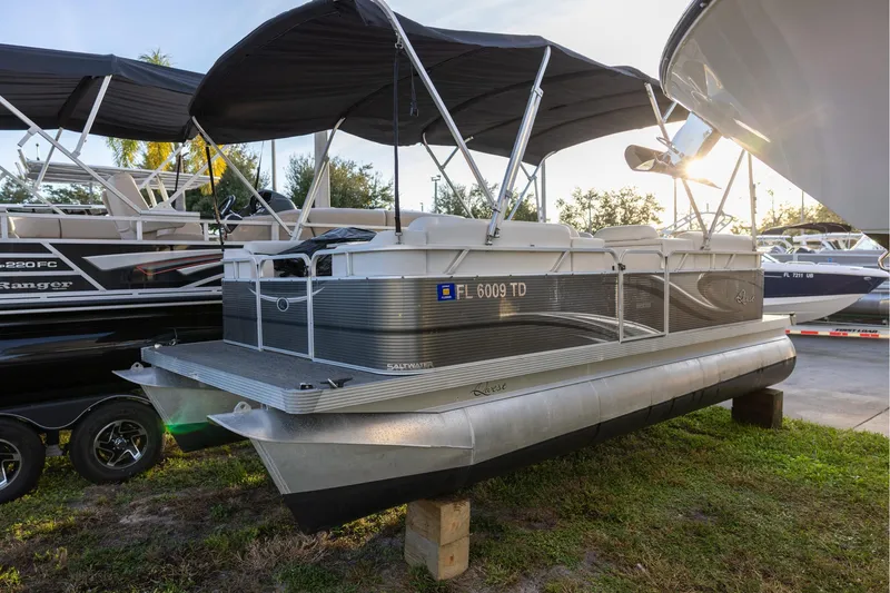 The Image of 2022 Qwest Lanai 818 pontoon boat with canopy, parked on grass. - 0