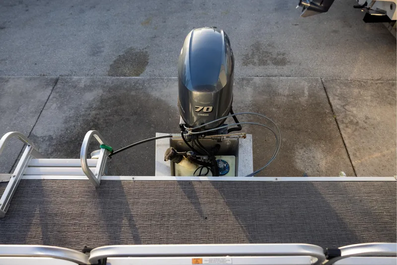 Slide: The Image of 2022 Qwest Lanai 818 boat with Yamaha 70 outboard motor, docked on concrete surface. - 4