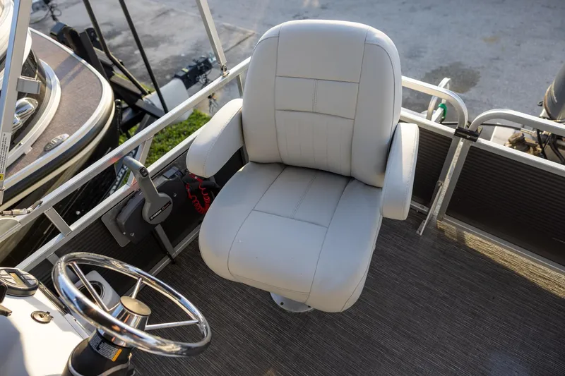 Slide: The Image of Captain's chair on 2022 Qwest Lanai 818 pontoon boat, featuring steering wheel and controls. - 7