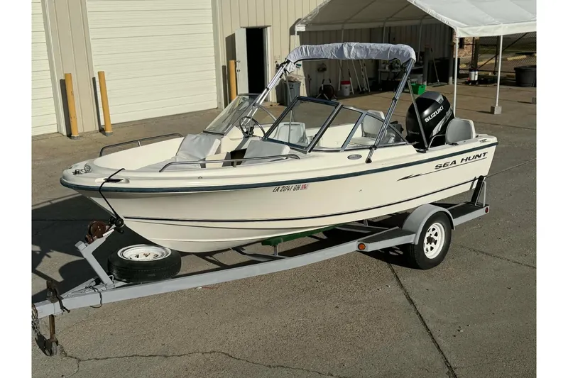 Slide: The Image of 2002 Sea Hunt Escape 175 boat on trailer, parked outdoors. - 1