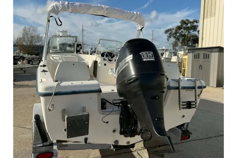 Slide: The Image of 2002 Sea Hunt Escape 175 boat with Suzuki 115 outboard motor, docked outdoors. - 10