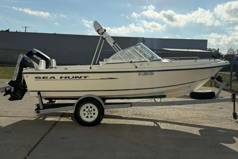 Slide: The Image of 2002 Sea Hunt Escape 175 boat on trailer, featuring Suzuki outboard motor. - 12