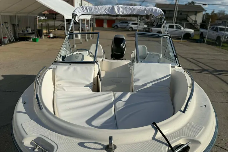 Slide: The Image of 2002 Sea Hunt Escape 175 boat with white seating and windshield, parked outdoors. - 2
