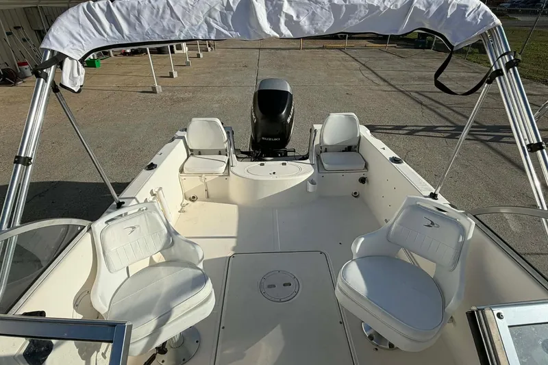 Slide: The Image of 2002 Sea Hunt Escape 175 boat interior with seating and canopy, featuring a Suzuki outboard motor. - 4