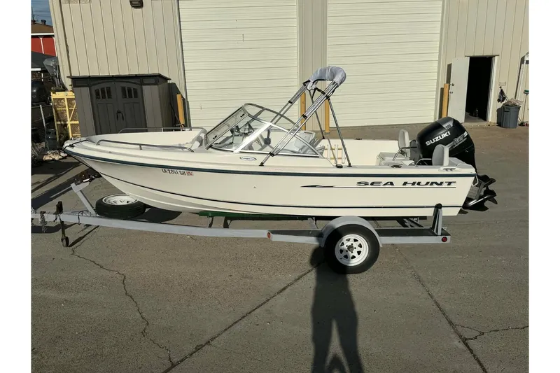Slide: The Image of 2002 Sea Hunt Escape 175 boat on trailer, parked outside a garage. - 5