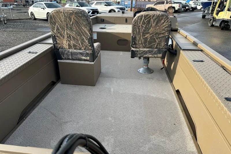 Slide: The Image of 2023 SMOKERCRAFT 1660 SPORTSMAN PRO SC boat interior with camo seats and spacious deck. - 3