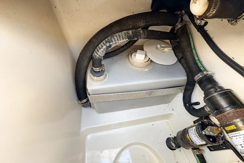 Slide: The Image of 2007 Triton 351 CC boat compartment with hoses and pump system. - 102