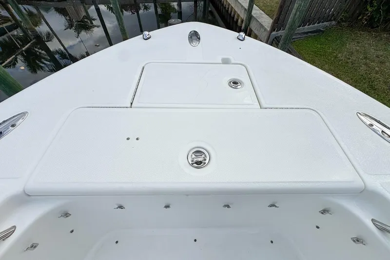 Slide: The Image of 2007 Triton 351 CC boat deck with storage compartments and stainless steel fixtures. - 105