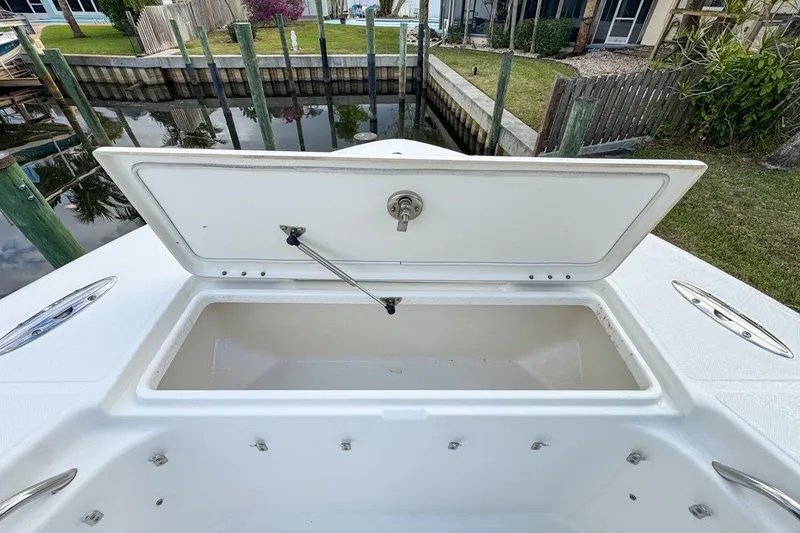Slide: The Image of Open storage compartment on a 2007 Triton 351 CC boat, docked by a canal. - 106