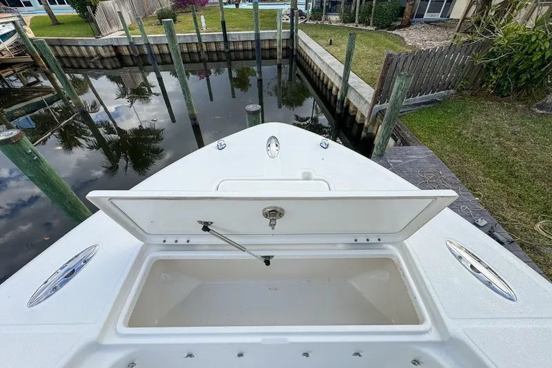 Slide: The Image of 2007 Triton 351 CC boat with open storage compartment, docked near a canal. - 108